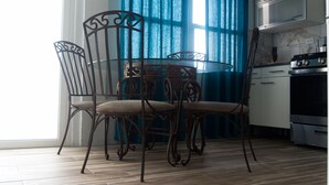 A kitchen with a dining table and chairs, a stove, and cabinets. - HIDDEN TREASURE (Point Blanche)