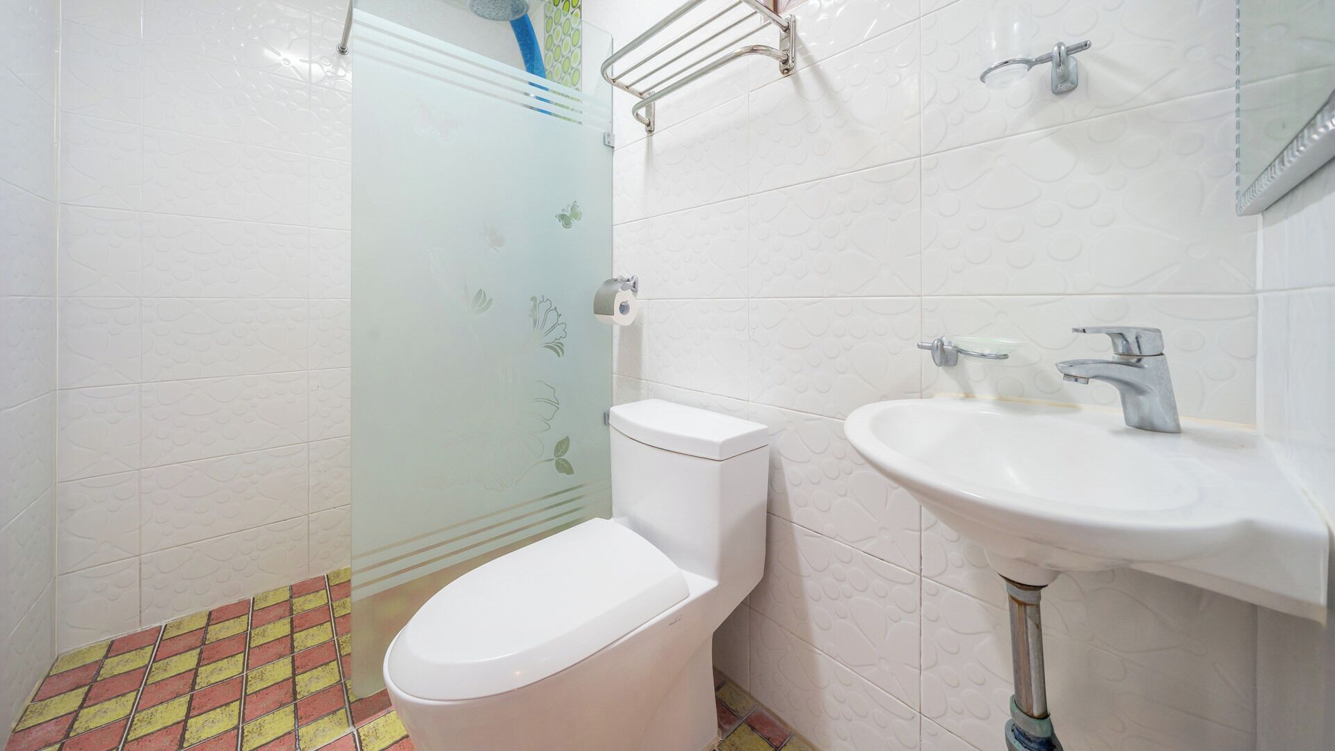 A bathroom with a toilet, sink, and shower.