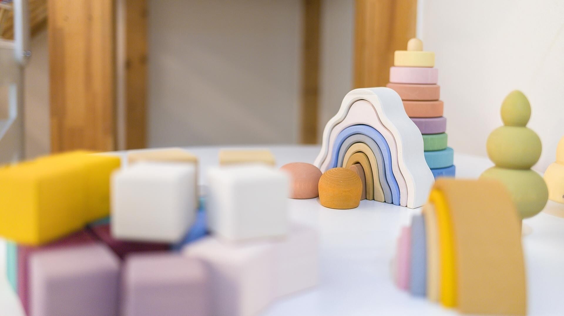 A room with a white table displaying various colorful blocks and a rainbow-shaped toy.