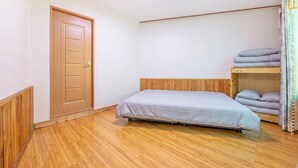 A room with a single bed, a wooden door, and a bunk bed with pillows. - Gapyeong Yeoul Kids Pension (Gapyeong)