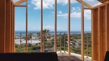Una habitación con vista al mar y un balcón con barandilla.