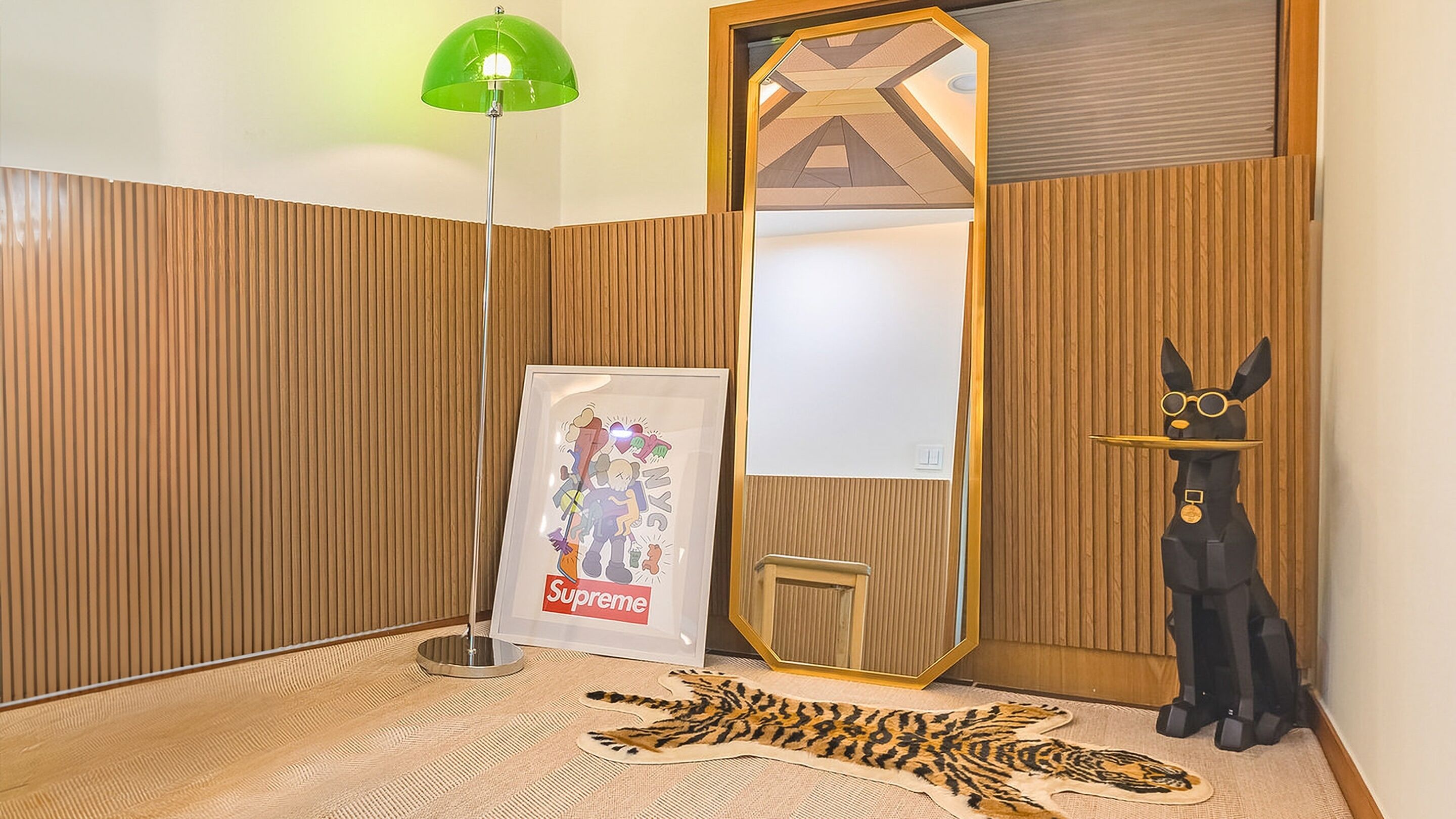 Um quarto com parede de painel de madeira, um abajur verde, uma obra de arte emoldurada, uma estátua preta e um tapete de pele de tigre.