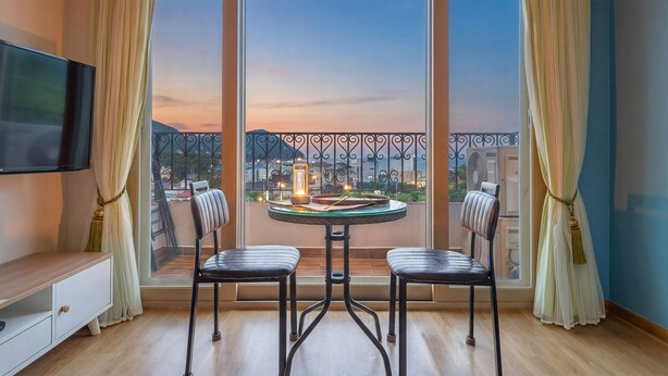 A balcony with two chairs, a table, and a TV. - Samcheok Yedaum Pension (Samcheok)