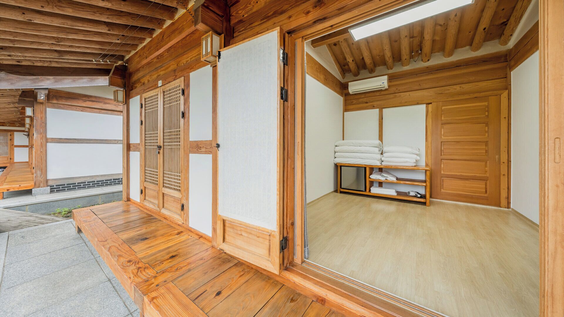 Ein traditioneller japanischer Raum mit Tatami-Böden, Schiebetüren und einem Regal mit Handtüchern.