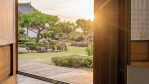 Un jardín japonés tradicional con un sendero de madera que lleva a una vista de una pagoda y árboles.