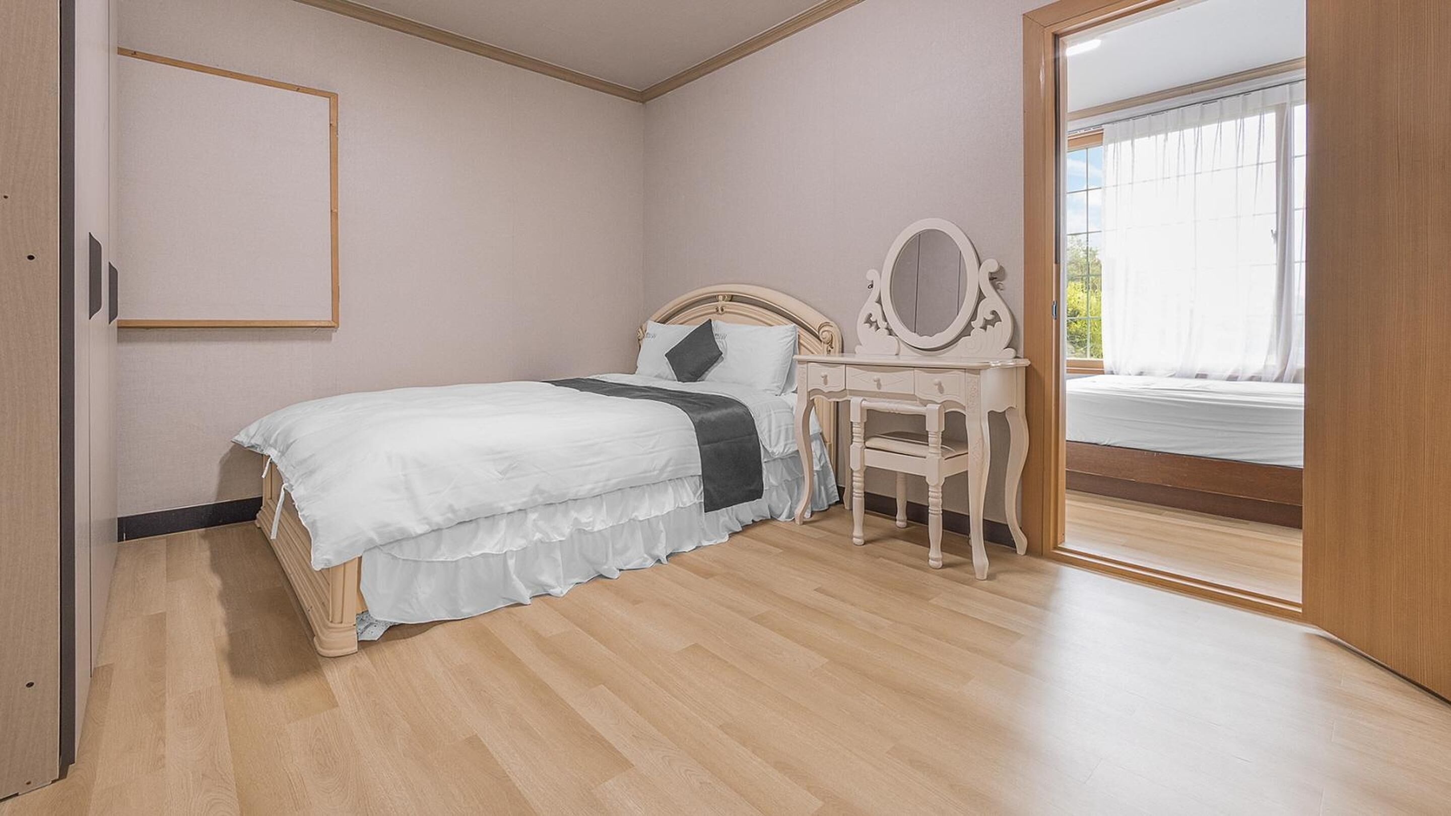 A bedroom with a bed, a dresser, and a mirror.