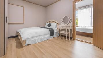 A bedroom with a bed, a dresser, and a mirror.