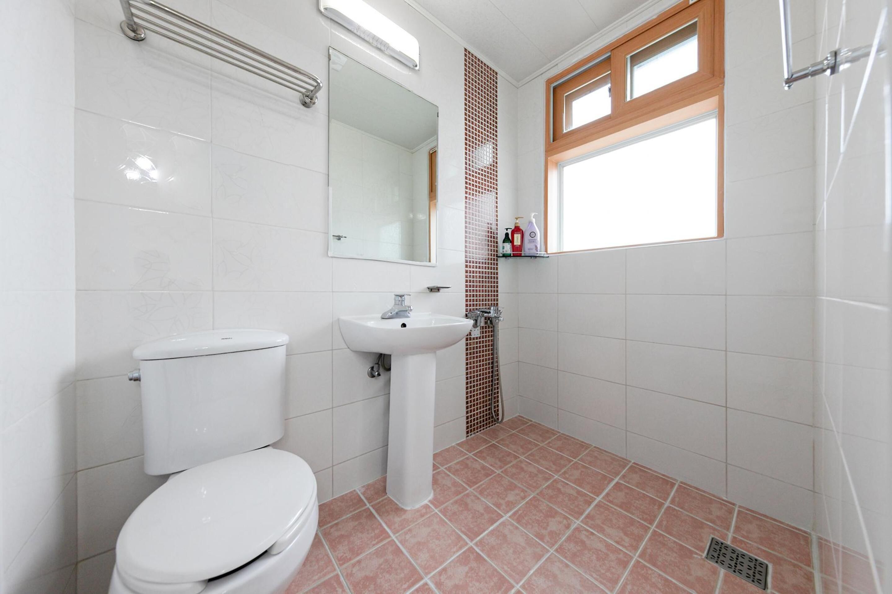 A bathroom with a toilet, sink, and shower.
