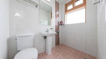 A bathroom with a toilet, sink, and shower.