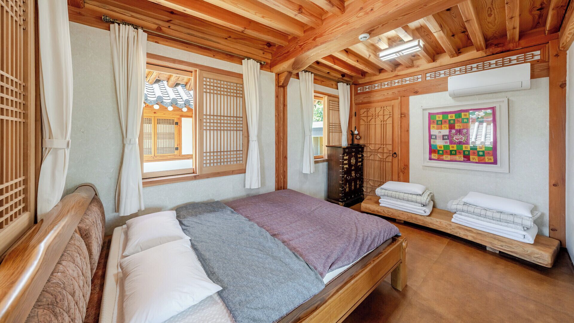 A traditional Japanese-style room with tatami flooring, a low wooden bed, sliding doors, and a shoji screen.