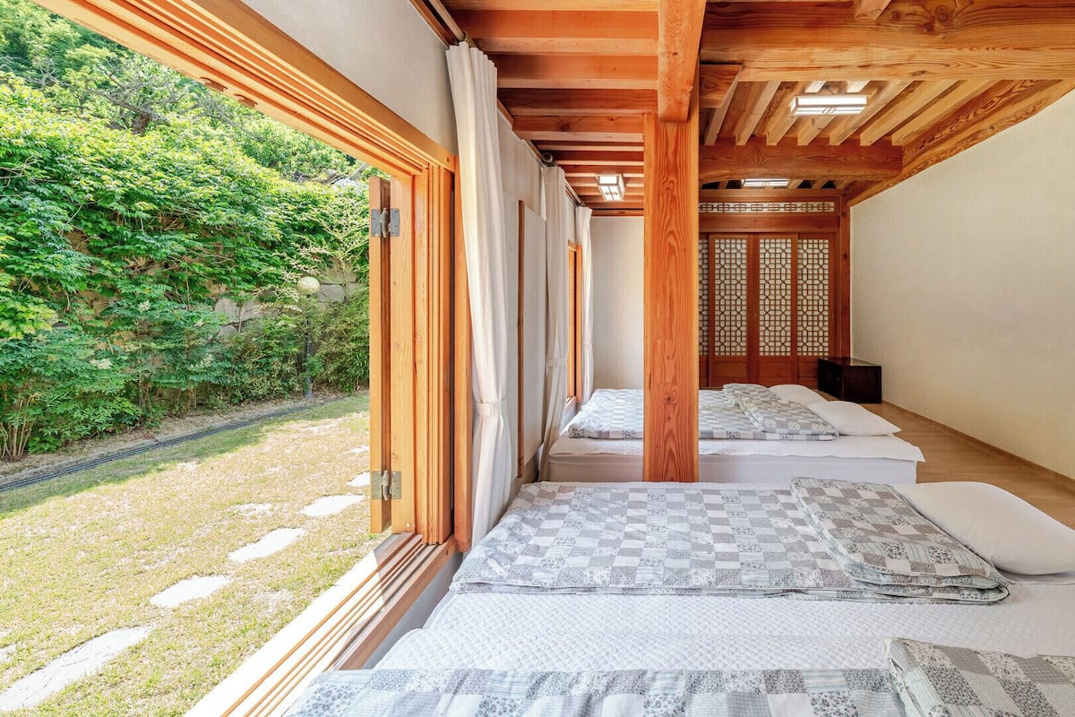A traditional Japanese-style room with tatami mats, wooden beams, and a sliding door.
