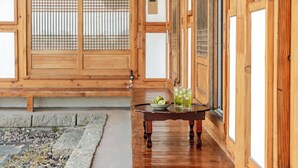 A traditional Japanese room with wooden sliding doors, a tatami mat floor, and a small table with a bowl of fruit and drinks. - Gyeongju Hanokhotel Chunchugwan (Gyeongju)