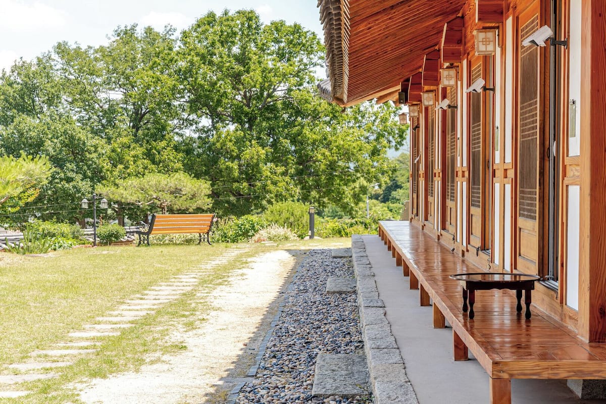 A traditional wooden building with a covered walkway and a bench.