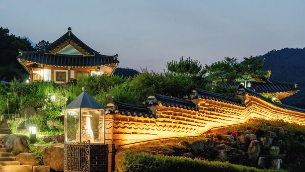 A traditional building with a curved roof, stone steps, and a lantern. - Gyeongju Hanokhotel Chunchugwan (Gyeongju)