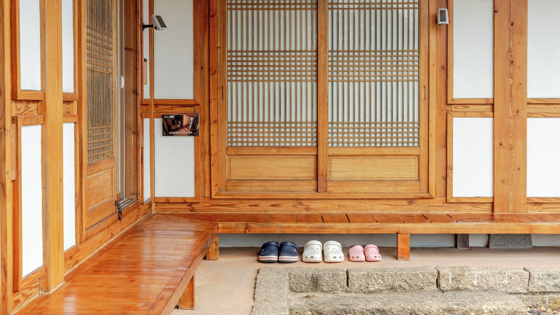 A traditional wooden entrance with sliding doors and a small bench.