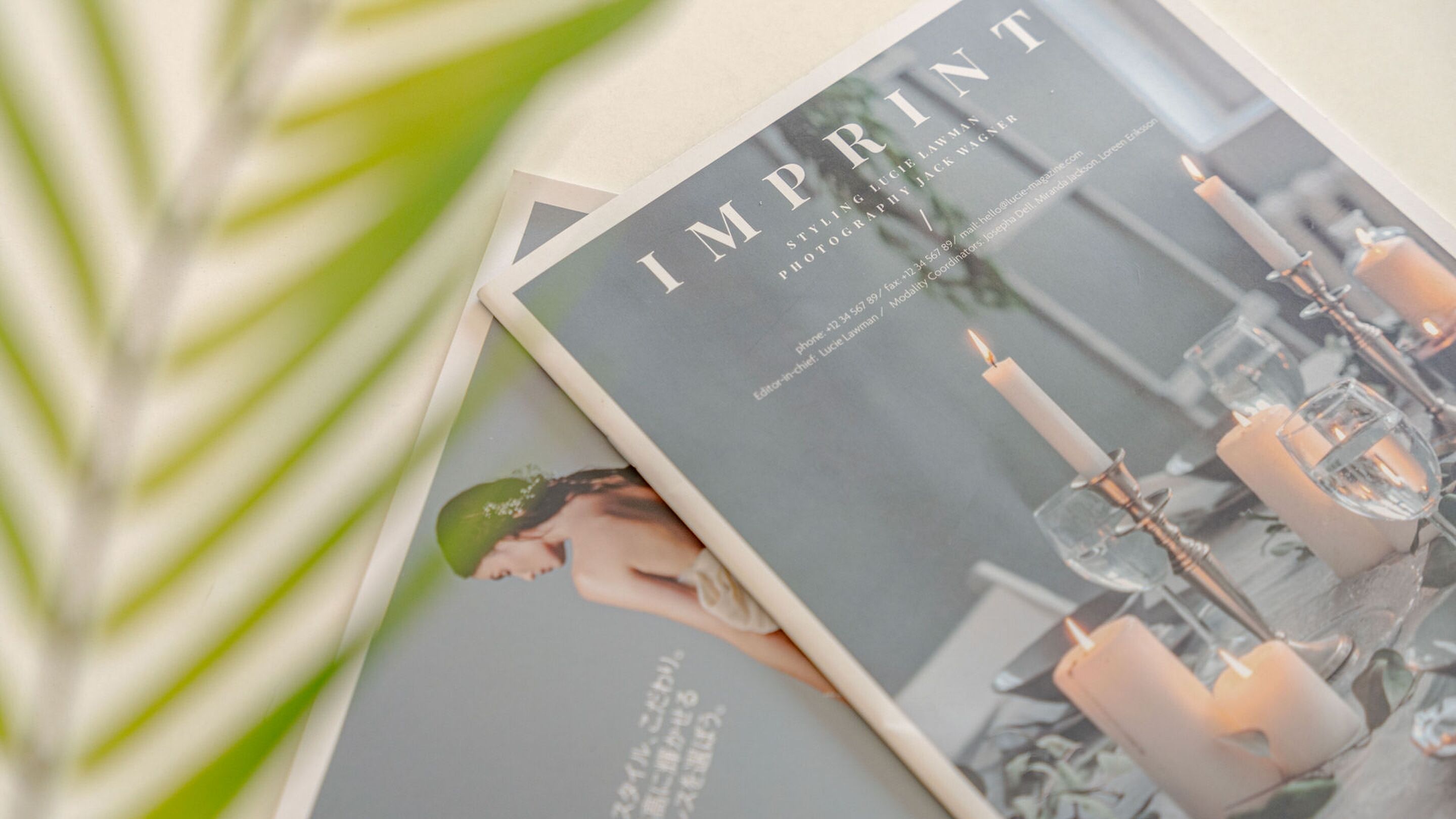 A magazine titled 'IMPRINT' with a photograph of a dining table set with candles and glasses.