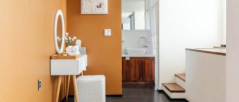 Un baño moderno con tocador, espejo y un ventanal grande.
