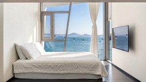 A bedroom with a large window, a bed, and a TV. - Namhae Pumda Pool Villa Pension (Namhae)
