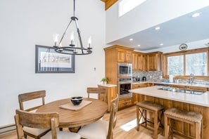 Enjoy cooking in this well-equipped kitchen with a central island, dining area, and large window offering a view of the outdoors.