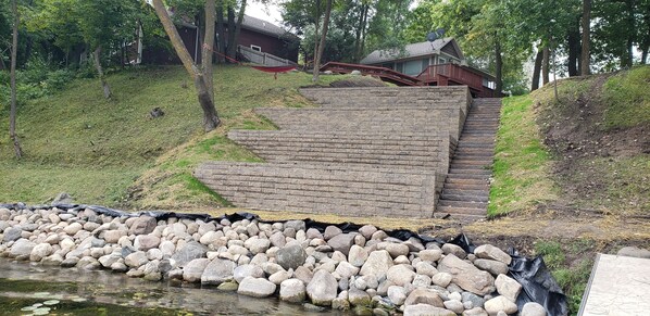 A stone staircase leading up to a house surrounded by trees.