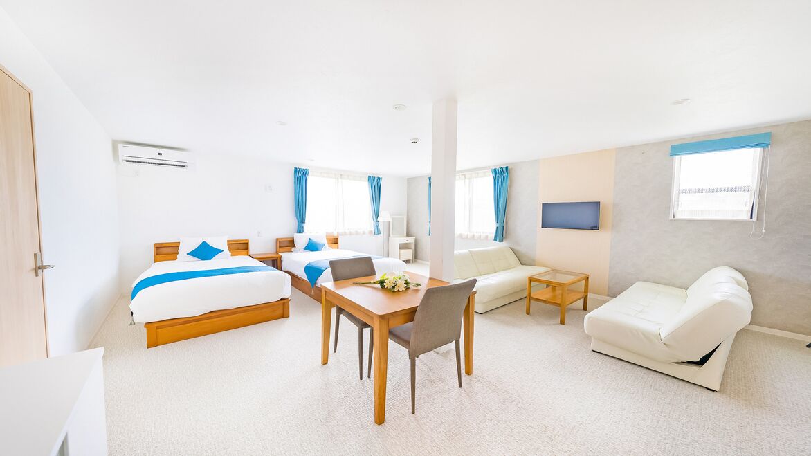 Una habitación de hotel con cama, escritorio, sofá y televisor.