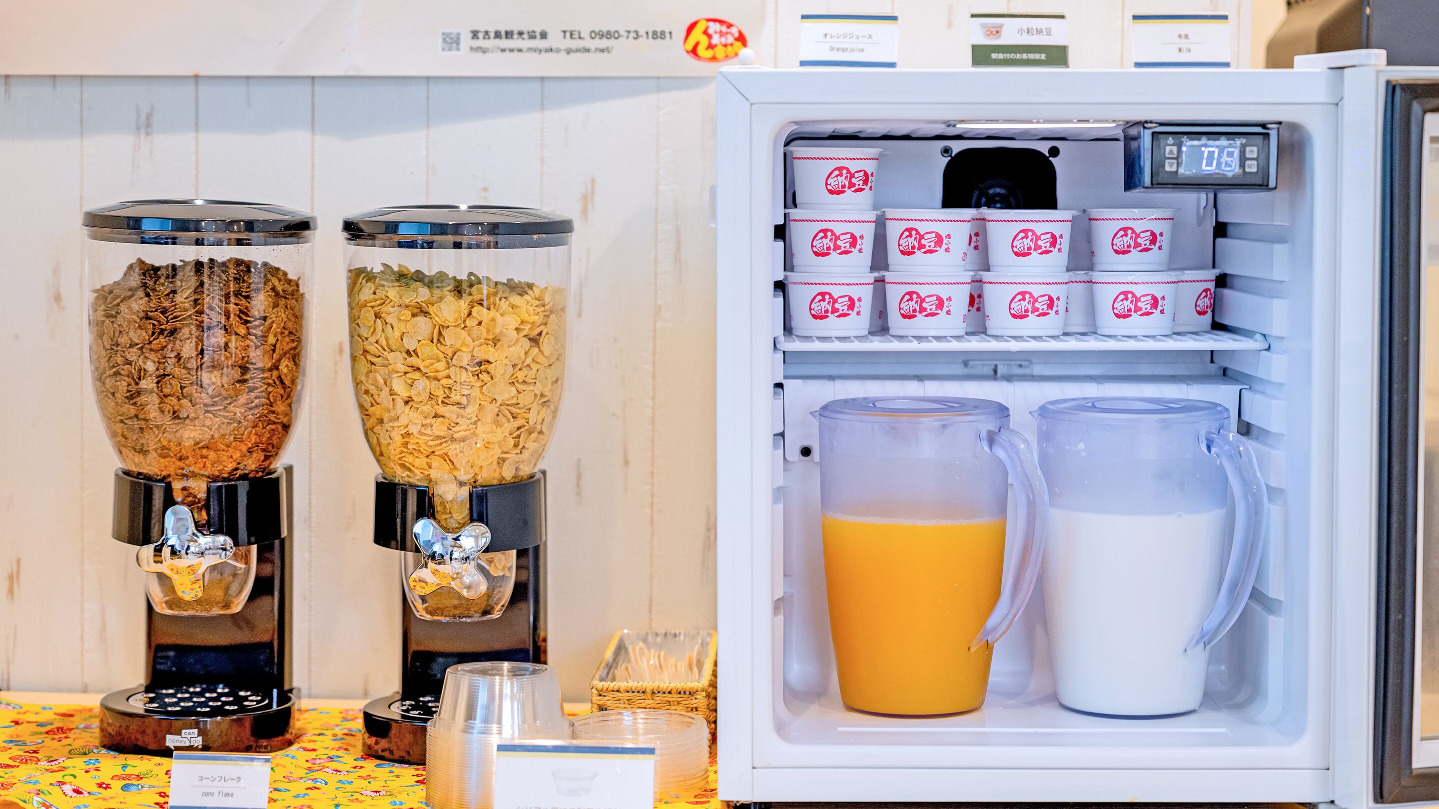 A refrigerator with two food dispensers, a milk jug, and a juice container.
