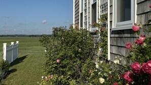 A house with a well-maintained lawn and a white picket fence. - New England, Coastal Beachside (DUXBURY)