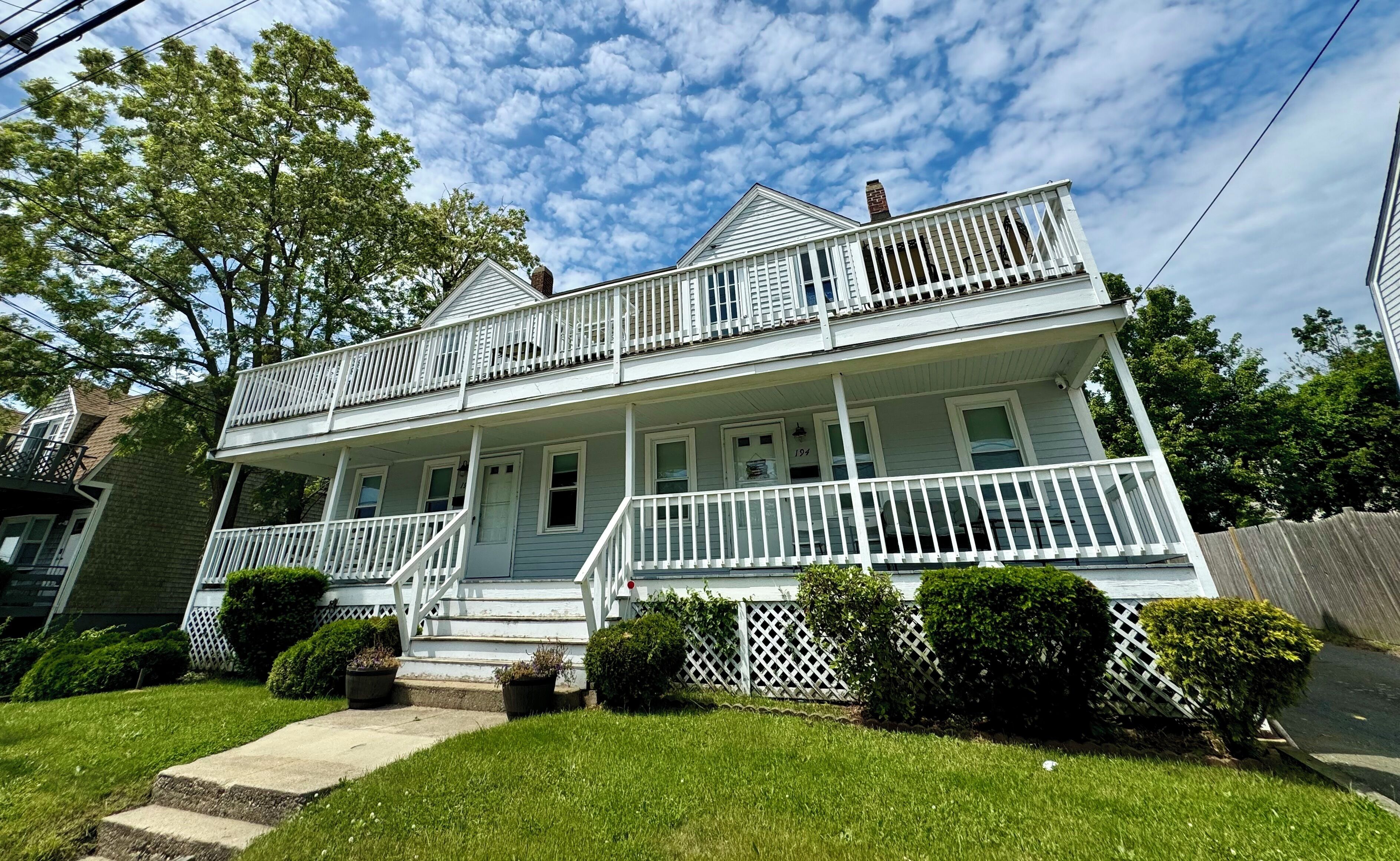 A two-story house with a front porch, a covered entryway, and a small front yard.