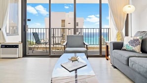 Une pièce avec un balcon, un canapé, une table et une chaise.