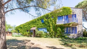 Une maison à deux étages, dotée d’une façade en pierre et d’une partie extérieure recouverte de lierre.
