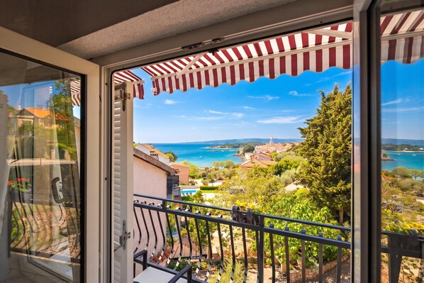 A balcony with a view of a coastal landscape, including a body of water and distant hills. - Seaview Apartment Micika Krk Island, Krk, Croatia (Krk)