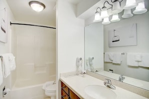 A modern bathroom with a bathtub, a large mirror, and a sink. - Steps to Trails-Pool-Hot Tub-W/D in Unit-Grill (Steamboat Springs)