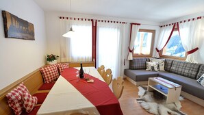 Un accogliente soggiorno con tavolo da pranzo, divano e tappeto in pelliccia.