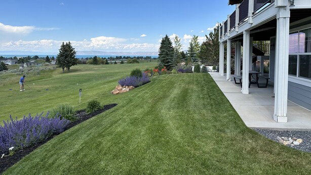 A residential property with a well-maintained lawn, outdoor seating area, and a view of the mountains. - Blue Lake Retreat - fully-landscaped home sits on 2nd tee of Bear Lake G.C. (Garden City)