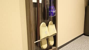 A pair of slippers hanging on a shoe rack in a hotel room.