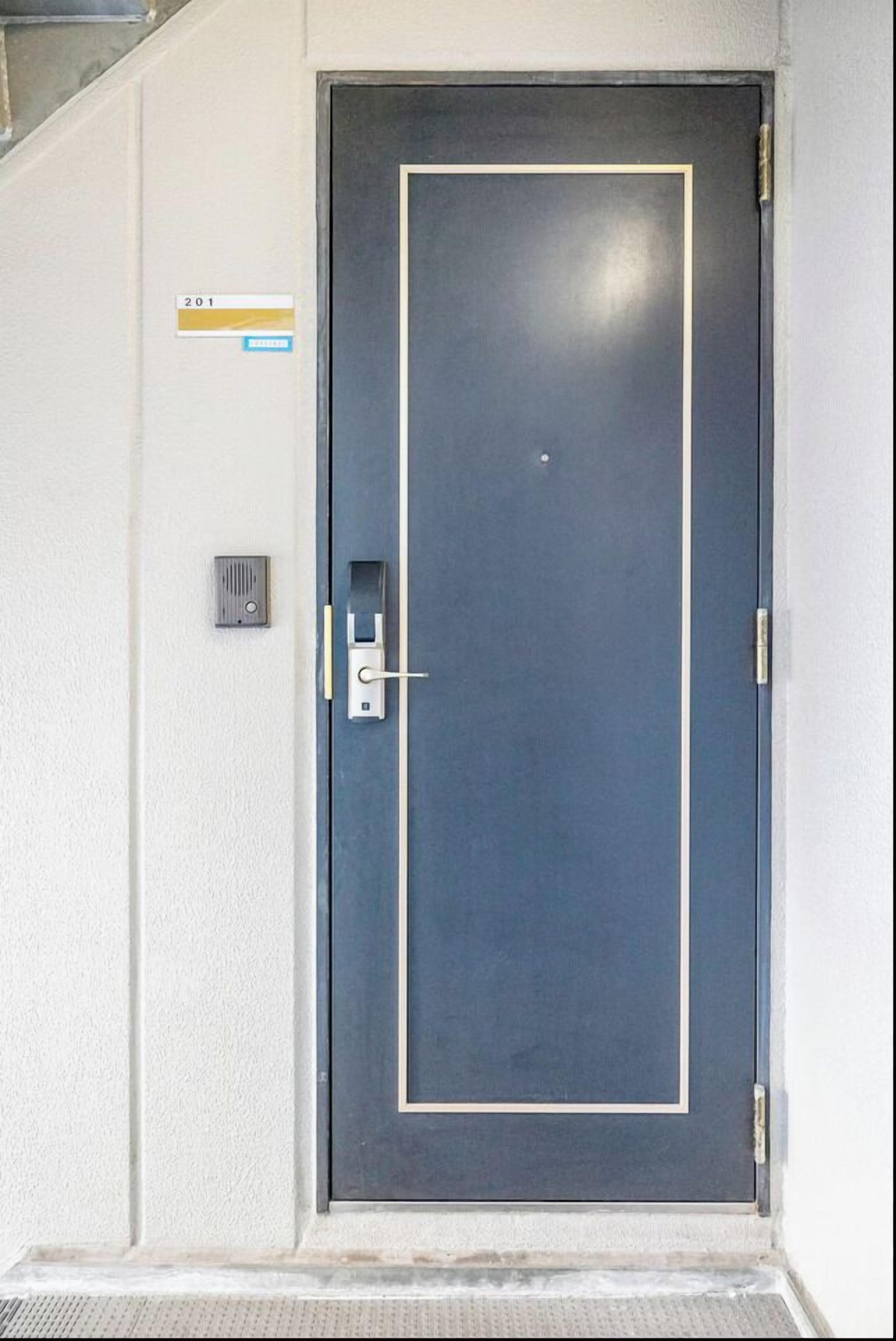 A closed door with a keyhole and a doorbell.