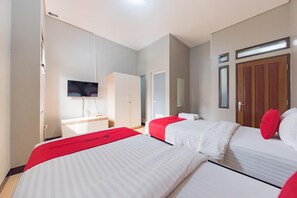 A hotel room with two beds, a TV, a wardrobe, and a mirror. - OYO 90026 Guest House Teras Waruga Syariah (Parongpong)