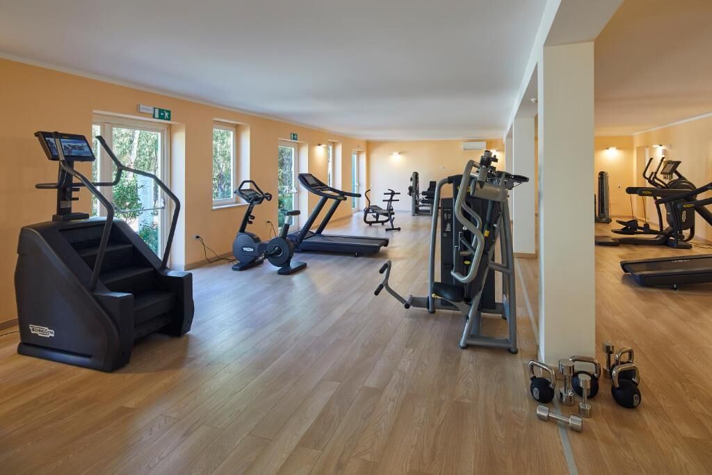 Un gimnasio con cintas de correr, elípticas y pesas libres.