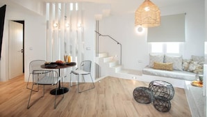 Una sala de estar moderna con comedor, una escalera y un área de descanso con vistas.