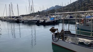 A marina with multiple boats docked, calm water, and a hilly landscape in the background. - Séjour de Rêve sur la Côte D'azur (Théoule-sur-Mer)