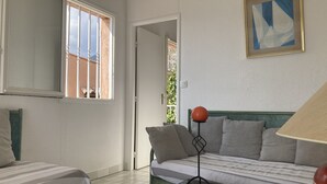 A bedroom with two beds, a window, and a painting. - Séjour de Rêve sur la Côte D'azur (Théoule-sur-Mer)
