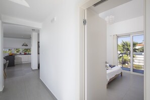 Une chambre d’hôtel moderne dotée d’un balcon, d’un coin cuisine et d’un espace repas.