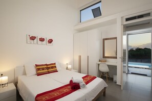 Een hotelkamer met een bed, een bureau, een stoel, een raam en kunst aan de muur.