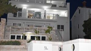 A modern two-story building with balconies, large windows, and a stone facade. - Villa Vita (Novalja)