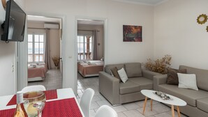 Uma sala de estar moderna com um sofá, uma mesa de centro e uma TV na parede.