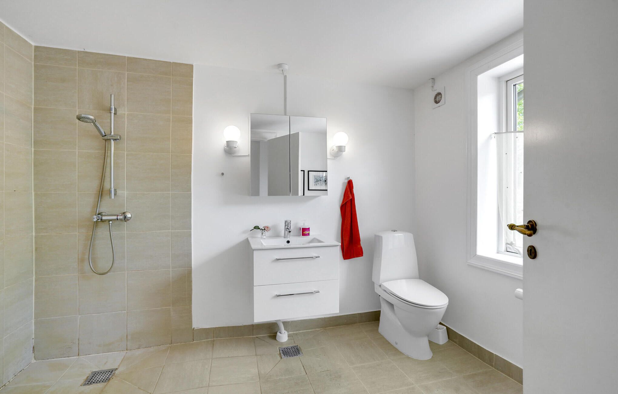 A modern bathroom with a shower, toilet, and sink.