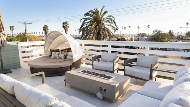 A rooftop terrace with a round seating area, a fire pit, and a white railing. - Close to the beach, train and all the downtown fun! (Oceanside)