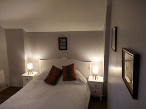 Cozy retreat with a large bed, two bedside tables, and a framed picture on the wall.
