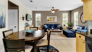 A modern living room with a dining table, sofas, and a kitchen area. - ☀️Pool+Nature Trails-30A-1st Floor-Sandy Feet Retreat☀️ (SANTA RSA BCH)
