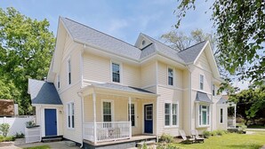 A two-story house with a front porch, a covered entryway, and a small front yard.